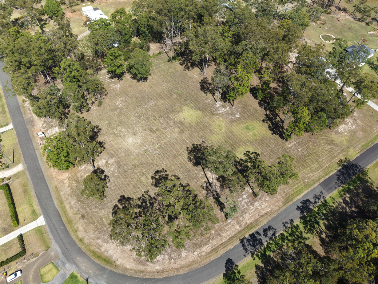 Aerial view of vacant land in Nabiac, NSW, surrounded by trees and road. Ideal for building a dream home.